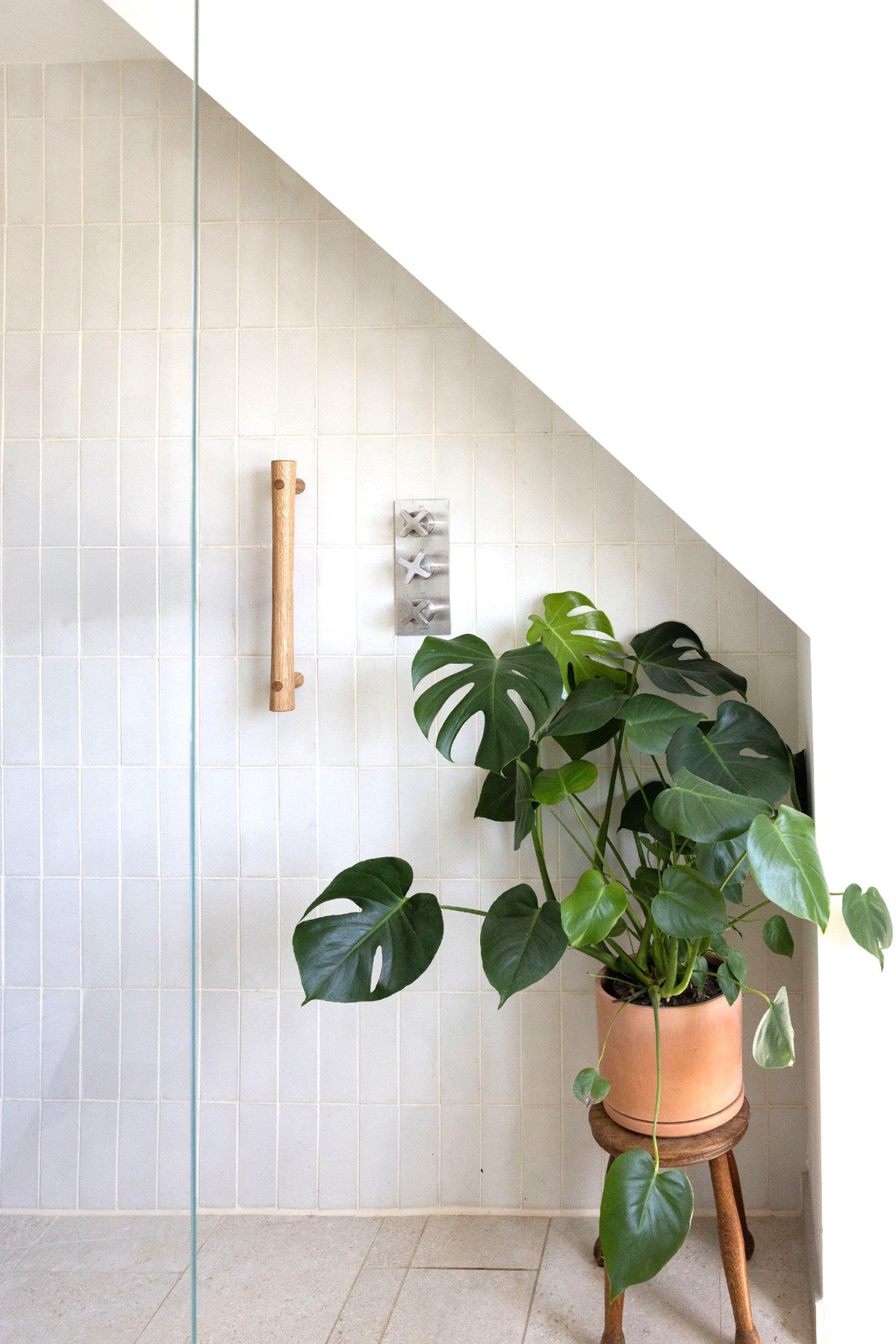 A warm minimal bathroom fitted with a Vivette solid-oak grab rail — the furniture-grade alternative