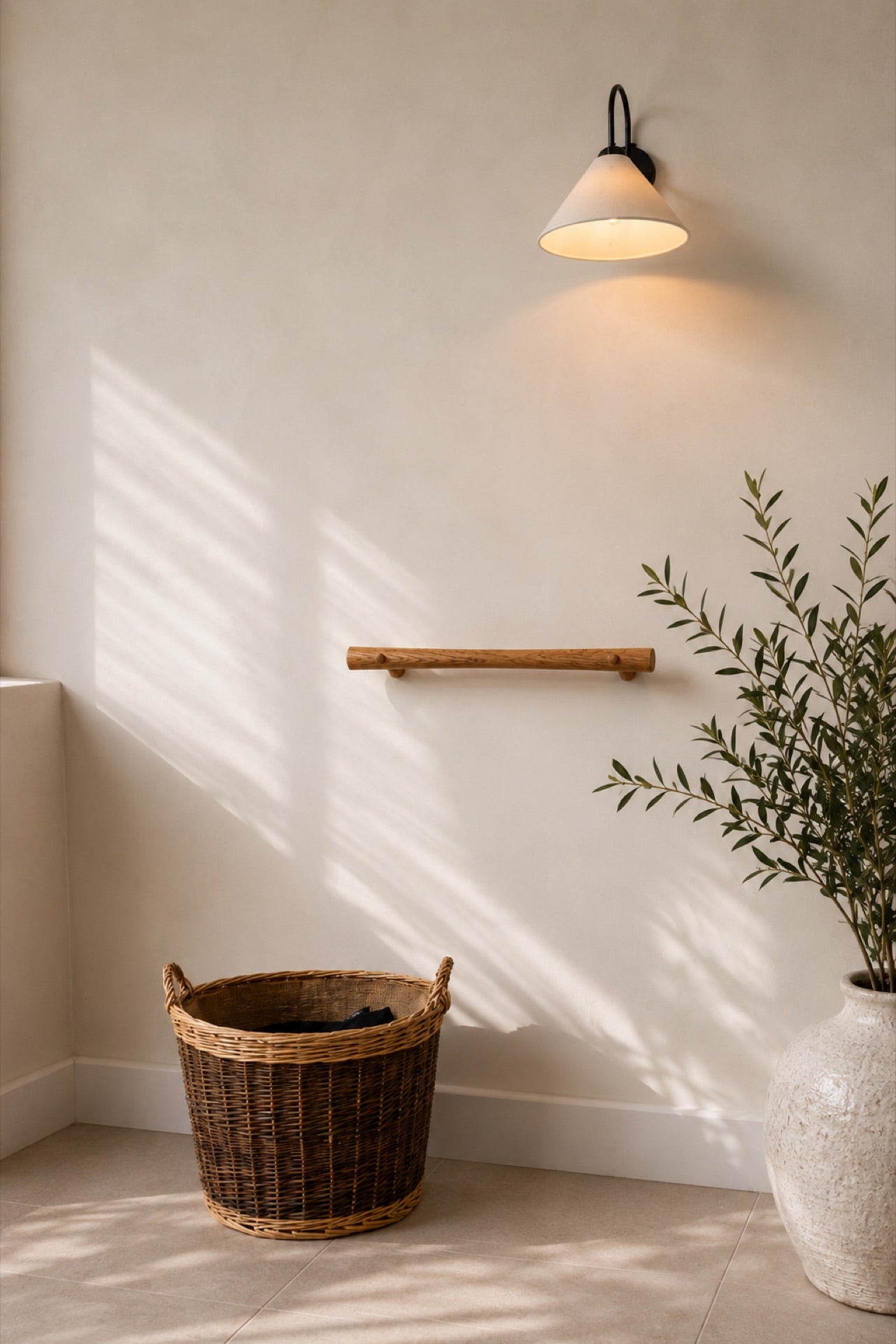 A Vivette oak grab rail mounted on a soft white wall above a wicker basket